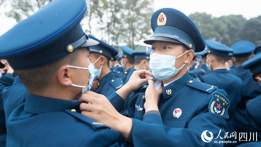 新戰(zhàn)士相互佩戴軍銜標(biāo)志服飾。西部戰(zhàn)區(qū)空軍某新訓(xùn)旅供圖