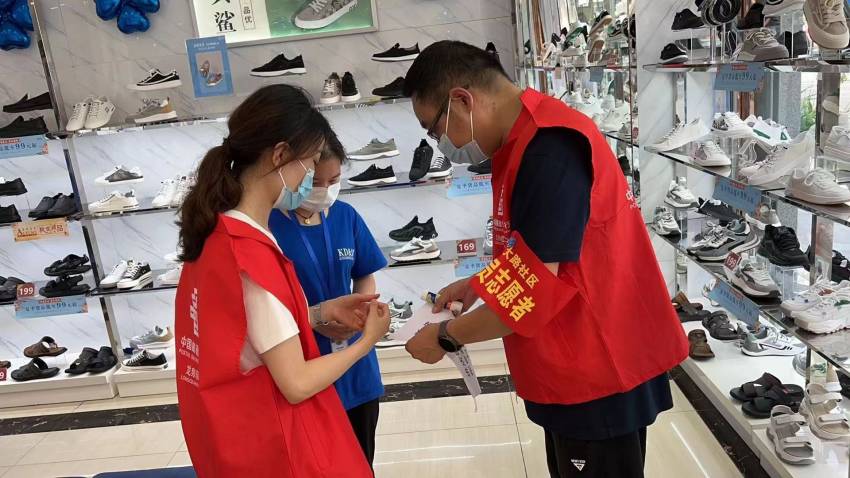 志愿者協(xié)助商家加強(qiáng)疫情防控。郵儲(chǔ)銀行龍泉驛區(qū)支行供圖