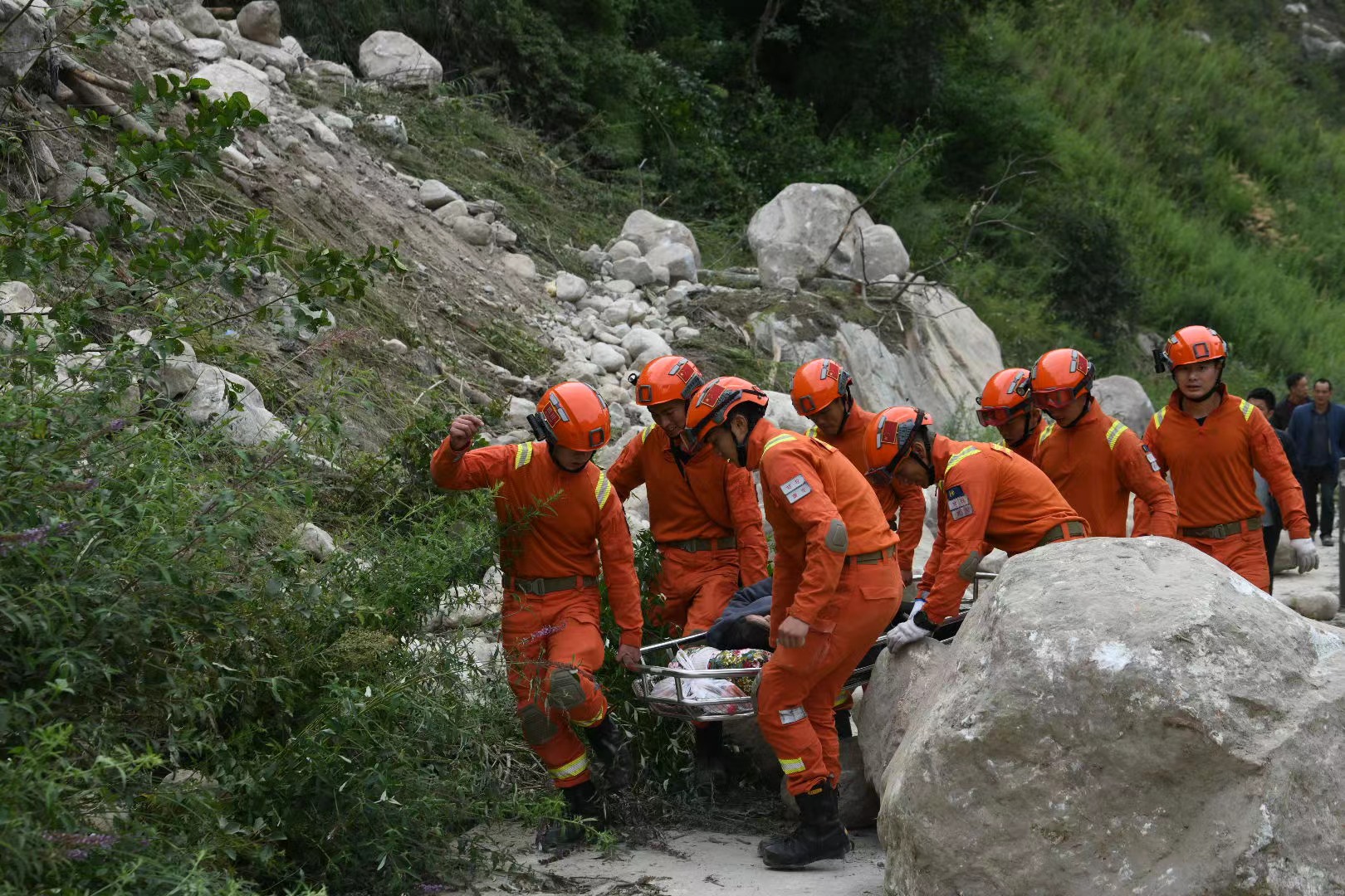 加固簡易橋梁，森林消防員護(hù)送傷員就醫(yī)。四川省森林消防總隊(duì)供圖