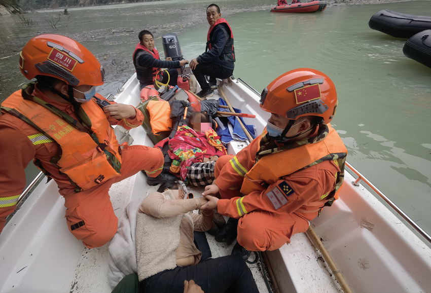 森林消防員利用橡皮艇在堰塞湖救助被困者。四川省森林消防總隊供圖