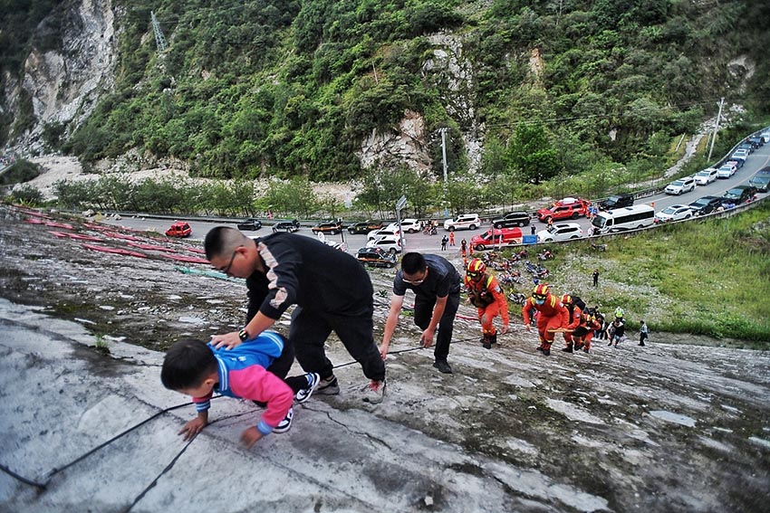 9月5日，消防救援人員因山體滑坡、道路中斷，通過攀爬挺進磨西鎮(zhèn)。四川省消防救援總隊供圖
