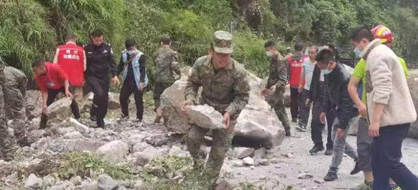 搬開落石清理道路。四川省軍區(qū)供圖