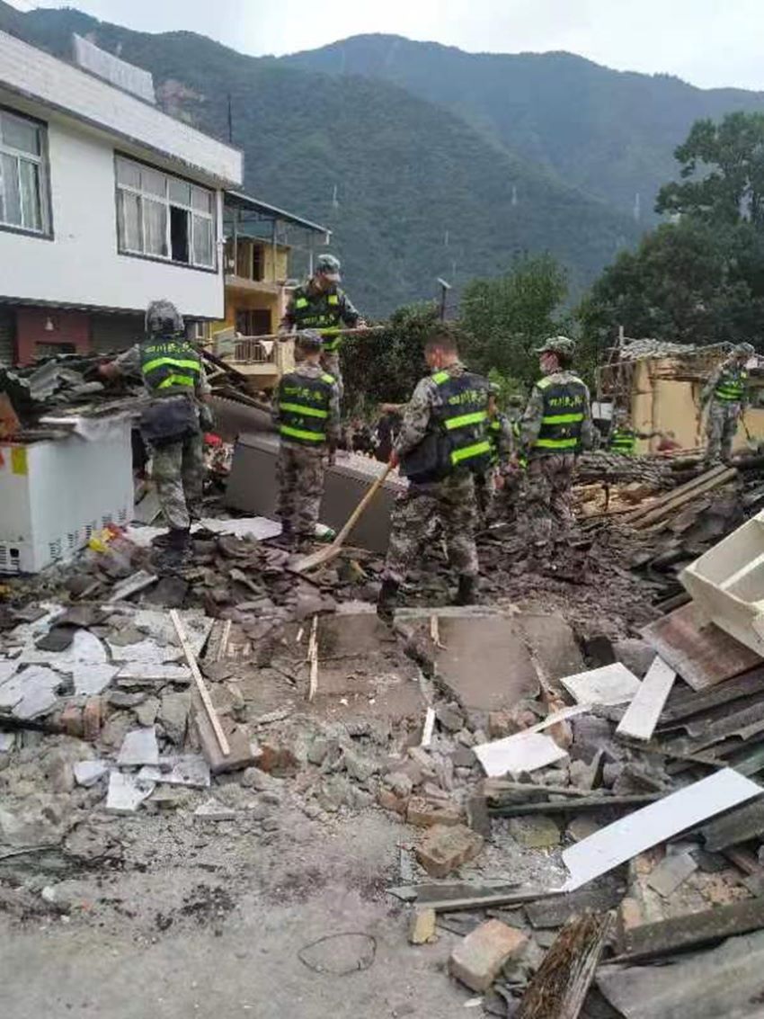 民兵在廢墟中開展搜救。四川省軍區(qū)供圖