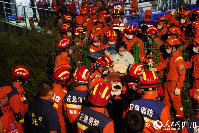 9月5日晚，雅安消防支隊在新民鄉(xiāng)碼頭，消防救援人員與多方救援力量一起運送傷員。鄭竺青攝
