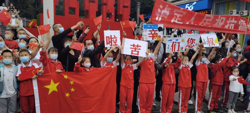9月13日，瀘定縣，當(dāng)?shù)鼐用衽e著條幅送別救援隊(duì)伍。程雪力攝