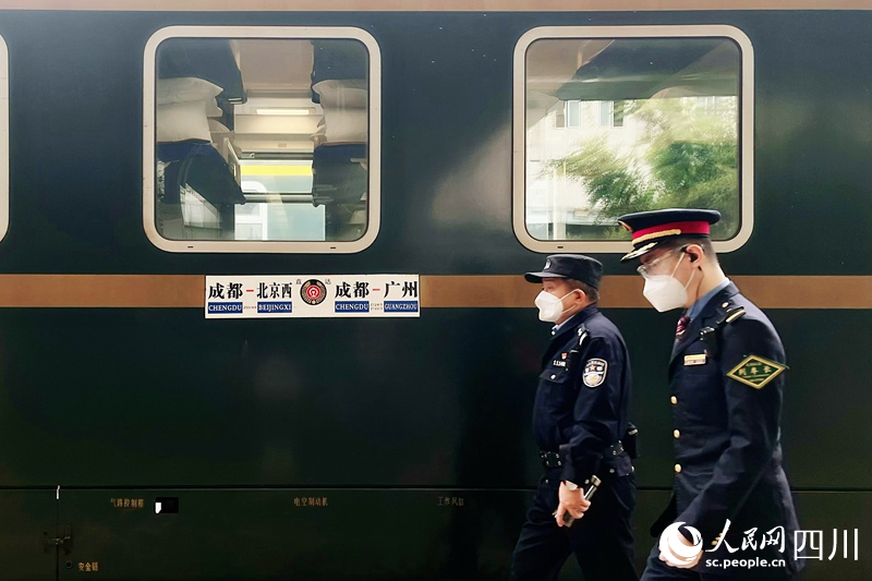 發(fā)車前，列車長(zhǎng)從列車前經(jīng)過。人民網(wǎng) 趙祖樂攝