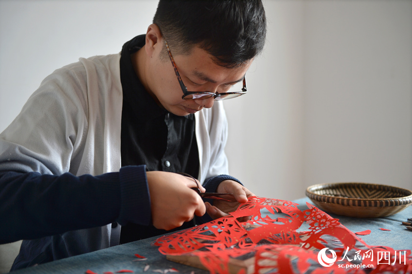 李有生在創(chuàng)作剪紙。王斌攝