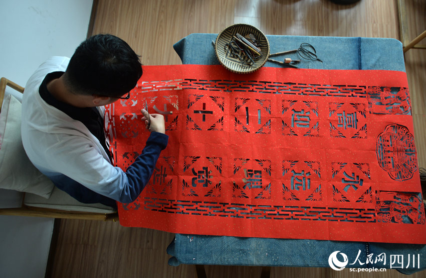 李有生在創(chuàng)作剪紙。王斌攝