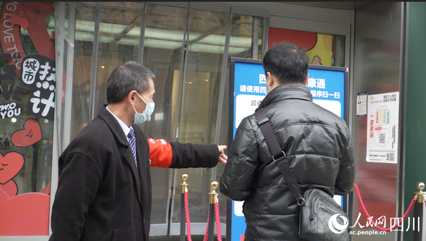 商場工作人員正在提醒市民掃場所碼。侯杰攝