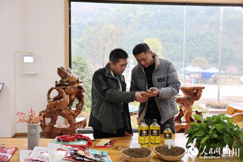 穆元奎（左）與李玨良探討幺麻子藤椒油產(chǎn)品。卓雪攝