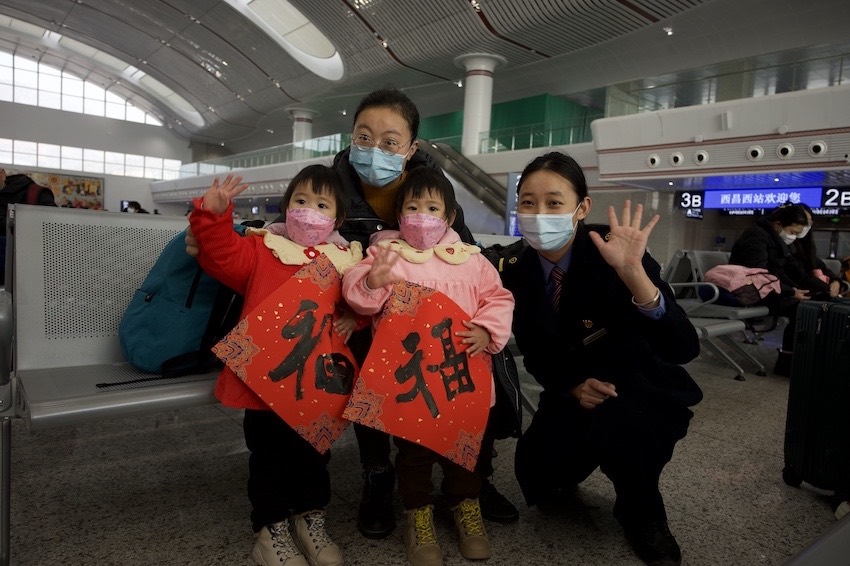 在沿途站點(diǎn)，車站工作人員為旅客送上“?！弊旨靶麓憾Y物。成都鐵路供圖