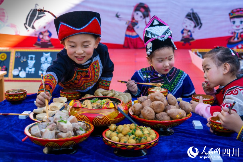 彝族年被稱為“嘴巴的節(jié)日”，圖為幼兒園內(nèi)的小朋友們在品嘗彝族傳統(tǒng)美食。范艷民攝