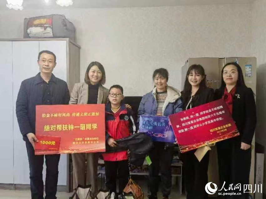 圖為愛心人士為鐘一瑁送去助學(xué)“大禮包”。劉佳雨攝