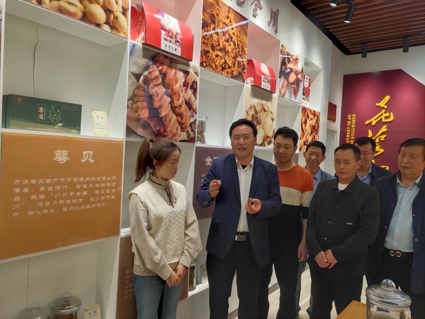 項家坪村支部書記龔代禮（左二）正在講述萼貝故事。達(dá)州市中醫(yī)藥管理局供圖