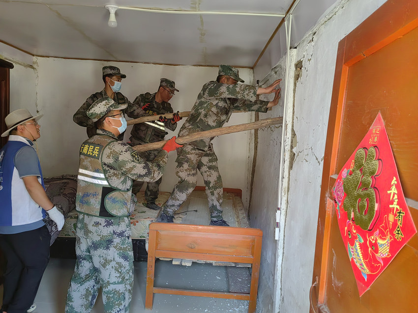 楊愛理（右一）在排除房屋安全隱患。陸軍第77集團(tuán)軍某旅供圖