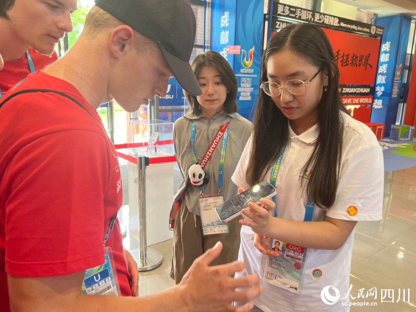 運(yùn)動(dòng)員咨詢二手手機(jī)的租借條件。 人民網(wǎng)記者 王洪江攝