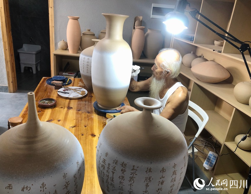 工匠正在陶器上刻字。鄧蕓攝