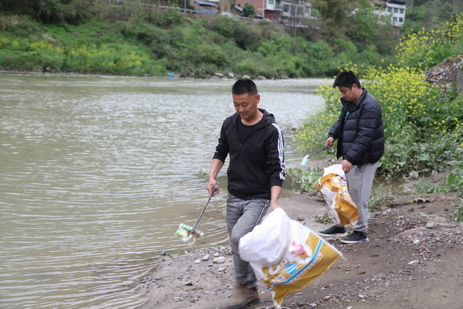 董正建父子在河道邊清理垃圾。馬發(fā)海攝
