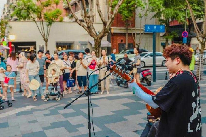 街頭藝人的表演深深吸引路人。成都市武侯區(qū)玉林街辦供圖