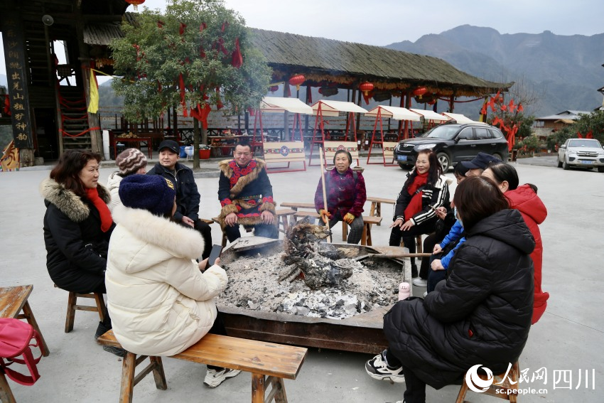 與村民和游客正在聊天的陳愛軍。人民網(wǎng)記者 朱虹攝