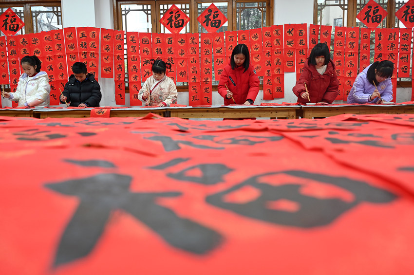 為社區(qū)居民書寫春聯(lián)和“?！弊?。蘭自濤攝
