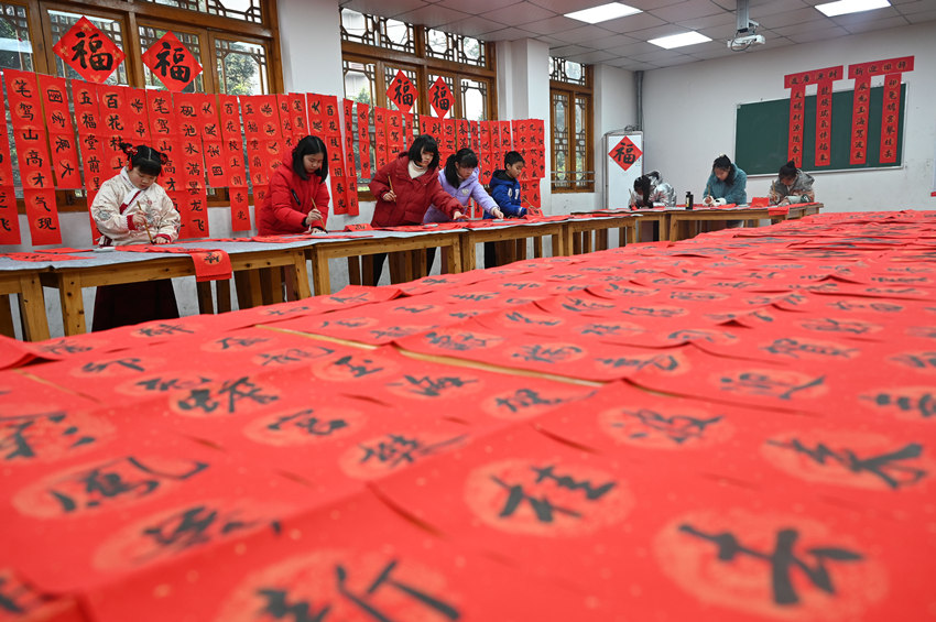 為社區(qū)居民書寫春聯(lián)和“?！弊?。蘭自濤攝