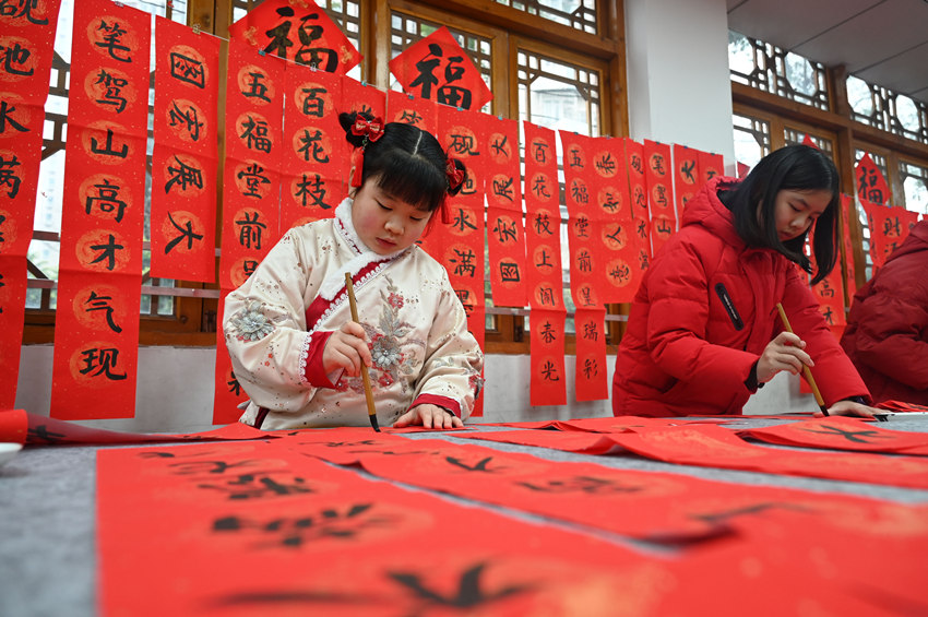 為社區(qū)居民書寫春聯(lián)和“?！弊帧Ｌm自濤攝