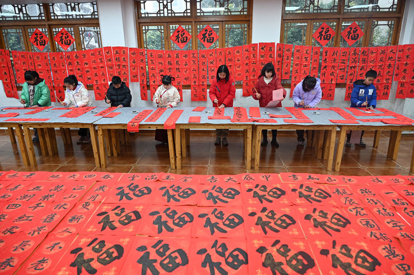 為社區(qū)居民書寫春聯(lián)和“?！弊帧Ｌm自濤攝