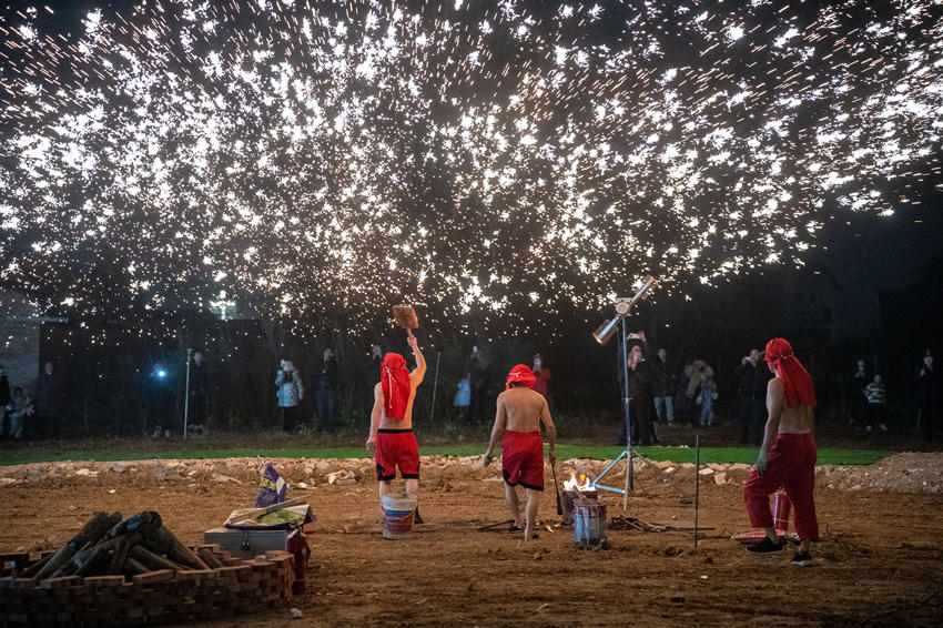 2月1日，傳統(tǒng)匠人在眉山市彭山區(qū)金燭村的萬家水碾夜市為群眾表演國家級非遺“打鐵花”。翁光建攝