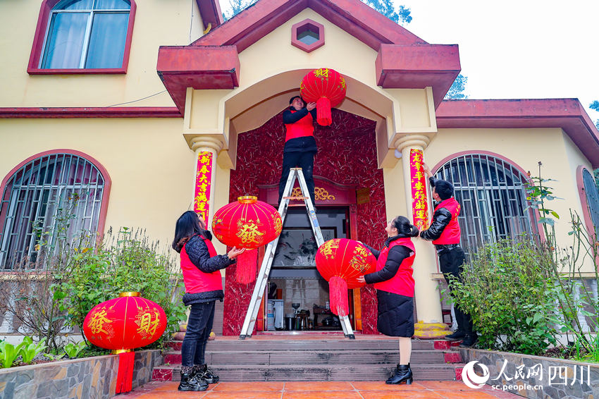 黨員志愿者們?yōu)楫數(shù)卮迕駫鞜艋\、貼春聯(lián)。牟科攝