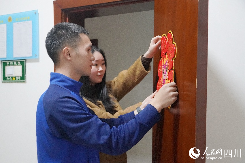 李明挺與熊一檔一起布置房間節(jié)日氛圍。曾平攝