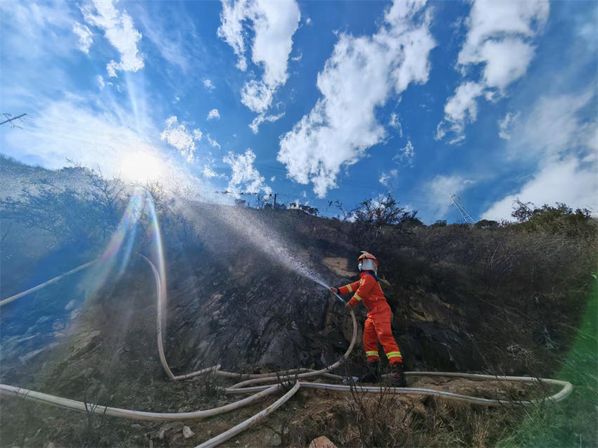 眉山市消防救援支隊救援人員利用40水帶出槍，對雅江縣降央寺周邊植被進(jìn)行澆灌、降溫冷卻。四川省消防救援總隊供圖