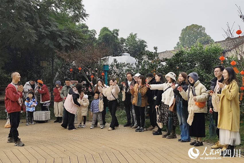 葉科（左一）給前來參與活動(dòng)的“柑爸柑媽”介紹生態(tài)種植果。人民網(wǎng)記者朱虹攝