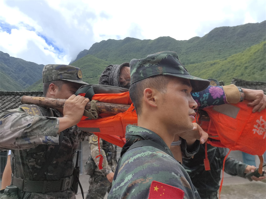 重災點轉(zhuǎn)移受災群眾。武警四川總隊雅安支隊供圖