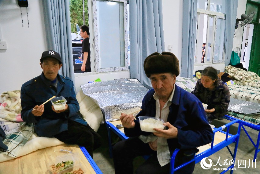7月21日晚7點，漢源縣馬烈鄉(xiāng)新華小學(xué)安置點的村民正在吃晚餐。人民網(wǎng)記者 朱虹攝