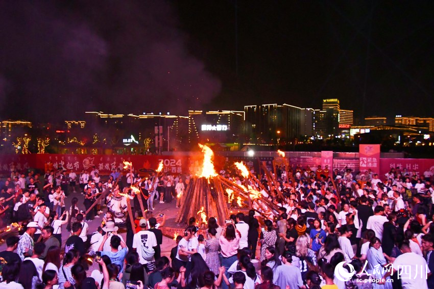 全場(chǎng)嘉賓、市民游客在火堆旁共跳達(dá)體舞。人民網(wǎng) 趙祖樂攝