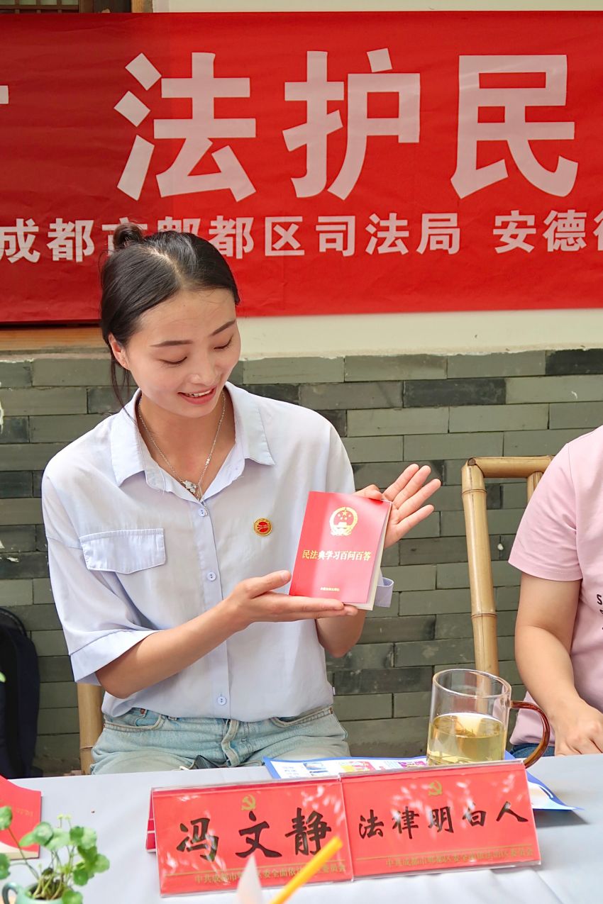 成都市“‘典’進鄉(xiāng)村 法護民企”民法典宣傳月活動現(xiàn)場，法律明白人為群眾介紹《民法典百問百答》讀本。成都市司法局供圖