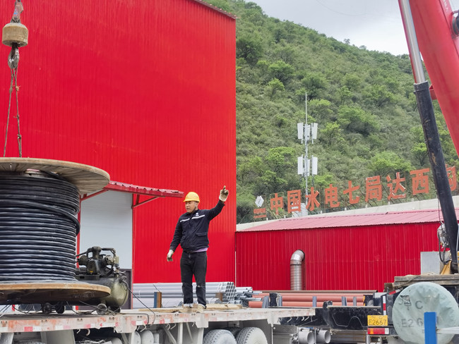 來自甘孜的洛絨達(dá)吉在家鄉(xiāng)水電站項(xiàng)目上指揮吊車裝卸電纜。水電七局供圖