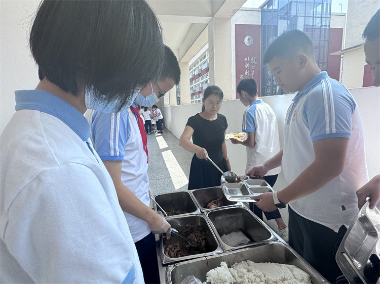 桑玉艷幫學(xué)生們打飯。青羊區(qū)教育局供圖
