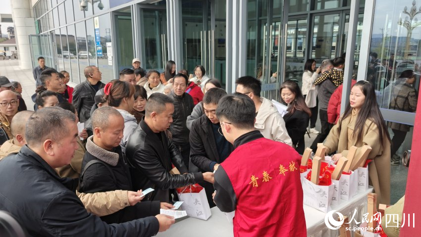 乘坐夾江站首發(fā)列車的旅客領(lǐng)取宣傳品。陳萱攝