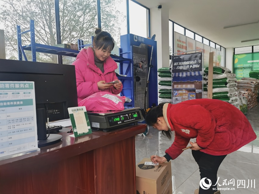 騎龍村金通快遞驛站，農(nóng)戶正在簽收網(wǎng)購的物品，農(nóng)村路的通暢也助力了工業(yè)品的下行。人民網(wǎng)記者 郭瑩攝