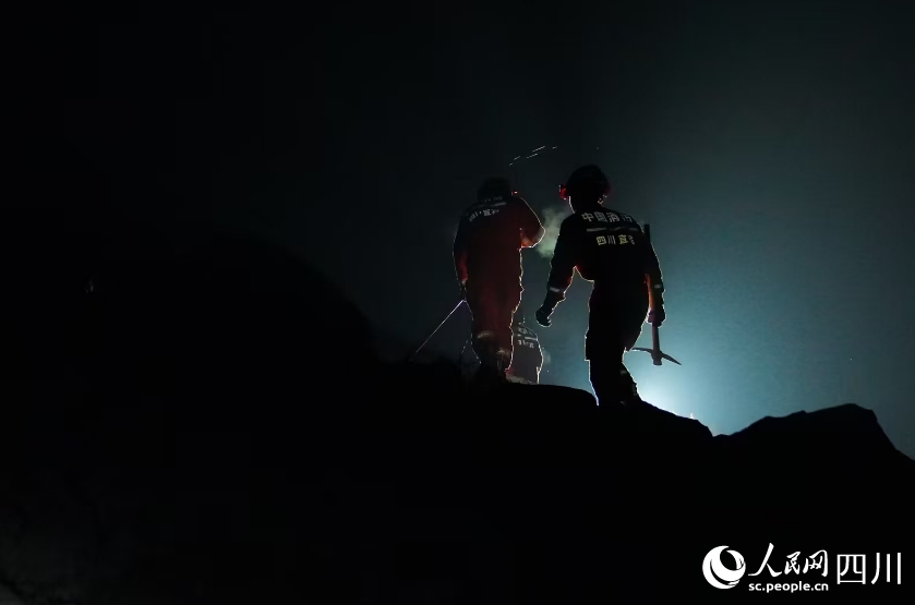 消防救援人員利用搜救犬、生命探測儀從下至上對垮塌廢墟進行搜索。宋豪新、黃超攝