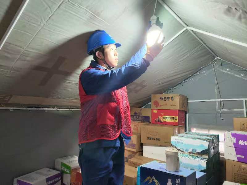 在受災群眾安置點，國網宜賓供電公司搶險支援人員第一時間為紅十字會救災帳篷安裝照明燈。楊義偉攝