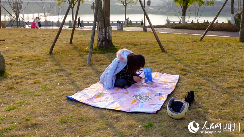 市民在花萼濕地公園草坪曬太陽。鐘欣航攝