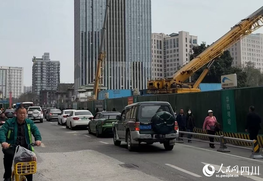 道路一側，地鐵建設穩(wěn)步推進，一邊，車流人流有序通行，建設單位加緊施工邊雨進一步釋放通行道路。人民網記者 郭瑩攝