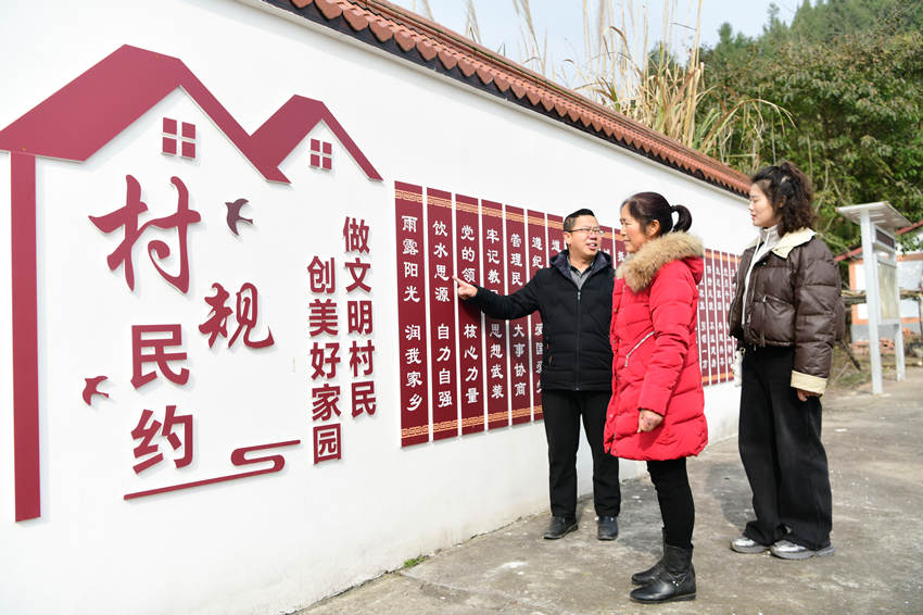 村民在三官村里閱讀村規(guī)民約。郭明攝