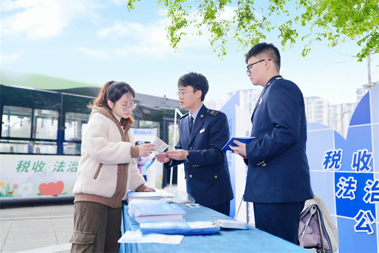 稅務(wù)干部在公交車站為納稅人講解稅收政策。成都市稅務(wù)局供圖