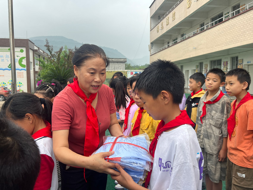 劉春香為鄉(xiāng)村留守兒童送去嶄新校服。中江縣委宣傳部供圖