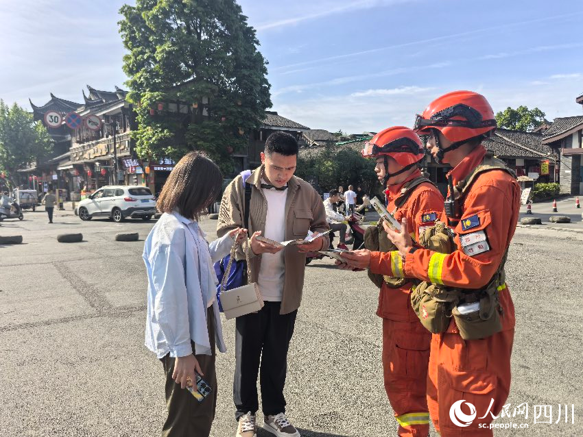 5月1日，都江堰景區(qū)，消防員唐平、譚弋飛正在進(jìn)行防火宣傳。程雪力攝