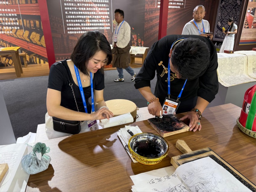 西博會非遺展示互動體驗區(qū)正在體驗的觀眾。甘孜州委宣傳部供圖